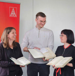 Lydia Oeser (Leiterin der Stadtbibliothek Burgstädt), Eddie Kruppa (1. Bevollmächtigter der IG Metall Chemnitz) und Elisabeth Geldmacher (SLUB Dresden) mit den drei restituierten Bänden (Foto: IG Metall Chemnitz, Lea Warda)